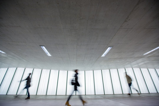 Motion blurred people - figures in an underpassage getting to their workplace in the morning. Busy city business life.