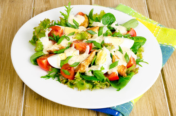 Salad of fresh vegetables, eggs, chicken meat with white sauce.