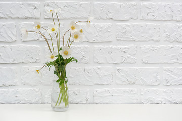 Bouquetof white wildflowers in vase on table background white brick wall Copy space Minimal style. Template for postcard, text, design Concept Women's day, Mothers Day, Hello summer or Hello spring