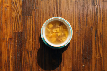 Fresh traditional delicious tasty compote of mixed fruits ; apricots, peach, apples and grapes on wooden table from top view.