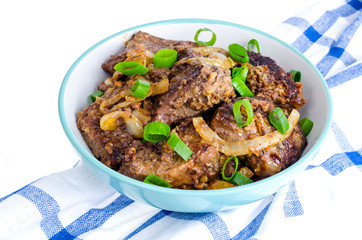 Fried liver with onions in bowl on white background.
