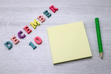 December 10 - Daily colorful Calendar with Block Notes and Pencil on wood table background, empty space for your text or design