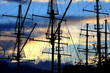 sailing boats silhouetted by sunset light in harbor of Antalya, Turkey