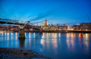 St. Paul's Cathedral across Millennium Bridge and the River Thames in London, UK.