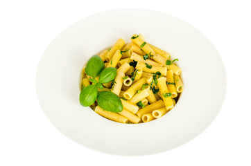 Penne pasta with spinach basil pesto sauce on white plate.