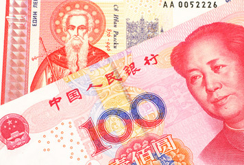 A Bulgarian one lev bank note with a red one hundred yuan renminbi Chinese bank note close up in macro