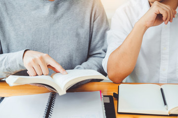 High school or college students studying and reading together in library