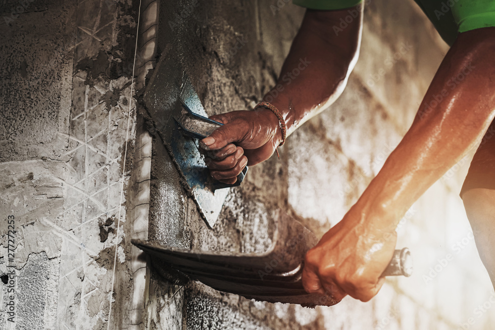 Wall mural closeup hand of worker plastering cement at wall for building house