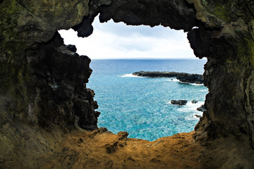 Rocky coastline with deep blue water on Easter Island, Chile, showcasing the island's natural...