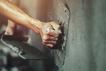 closeup hand of worker plastering cement at wall for building house - obrazy, fototapety, plakaty