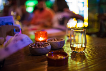 Single glass of whisky or whiskey on wooden table at pub, bar or restaurant at night. Scotch, bourbon or irish whiskey on wooden table. Nightlife concept image