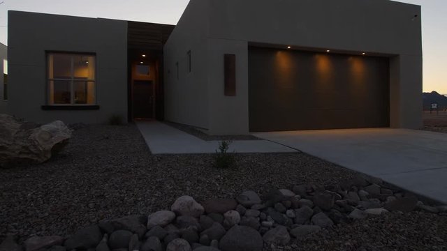 Southwest Home Exterior Rising At Night From Plant. View Moves Up On A Dusk Shot Of A Southwest Style Home In New Mexico