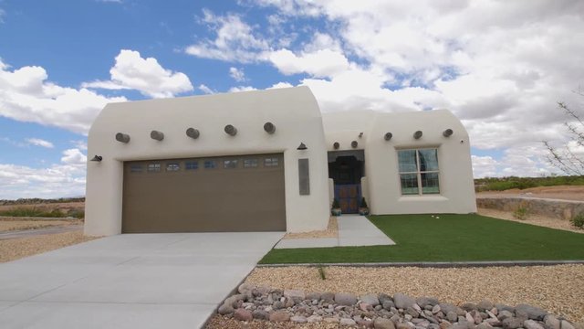 Southwest Home White Exterior Rise from Rocks. view moves up on a traditional new southwest style adobe home in New Mexico from rocks