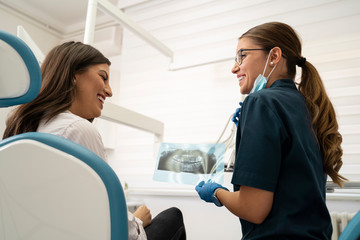 Obraz premium Female nurse / dentist showing her patient x-ray of her teeth, everything is OK