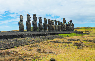 Ahu Tongariki with its iconic row of moai statues under a bright blue sky on a sunny day, Easter...