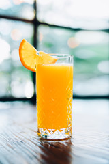 Glass of fresh orange juice on wooden table