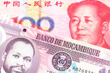 A purple, twenty metical note from Mozambique close up with a red, one hundred Chinese yuan bill