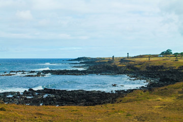 The scenic coastline and pier of Hanga Roa, the main village on Easter Island, Chile, featuring turquoise waters, rocky shores, and a peaceful atmosphere in a tropical setting.