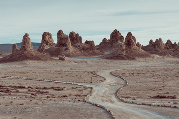 trona pinnacles seen from above. View of the formation. Dirty road and mountains in the background. 