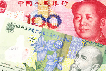 A close up image of a one Romanian leu bank note with a red, Chinese one hundred yuan renminbi note in macro