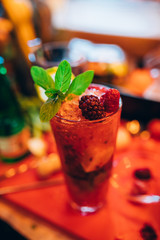 Red, fresh sBartender making Red, fresh summer alcoholic cocktail beverage with ice.ummer strawberry smoothie cocktail juice beverage with ice.