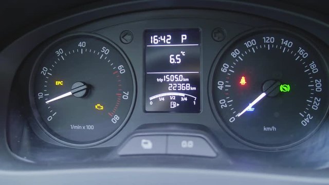 Car interior dashboard details with indication lamps, switching and lighting instrument panel with visible speedometer and fuel level.