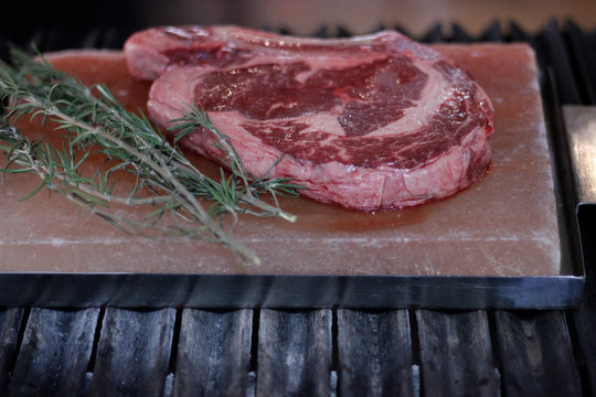 Corte de carne cruda con ramas de romero 