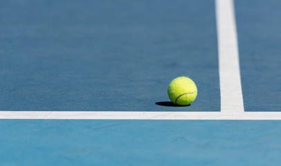 Tennis ball on blue tennis court
