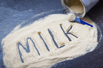 Milk powder on dark background / powdered milk can , food healthy body from protein or for baby