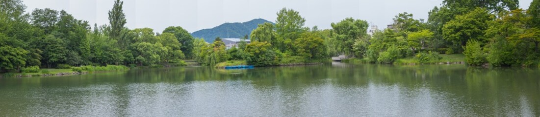 Fototapeta na wymiar Panorama beautiful landscape view of Lake surrounded with green trees in Nakajima Park (Koen) in Sapporo City, Hokkaido, Japan.