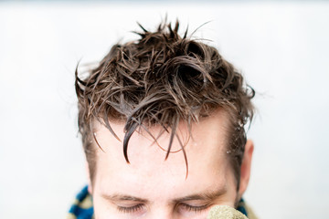 wet men hair and holding a towel after taking a shower at home