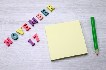 November 17 - Daily colorful Calendar with Block Notes and Pencil on wood table background, empty space for your text or design