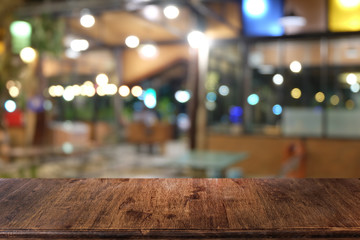Empty dark wooden table in front of abstract blurred bokeh background of restaurant . can be used for display or montage your products.Mock up for space.