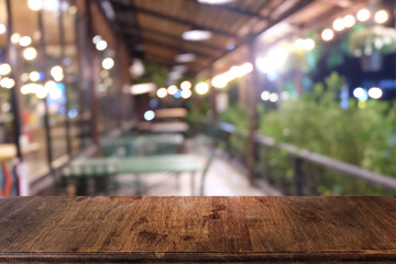 Empty dark wooden table in front of abstract blurred bokeh background of restaurant . can be used for display or montage your products.Mock up for space.