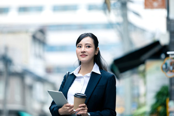 タブレットPCとドリンクを持つビジネスウーマン