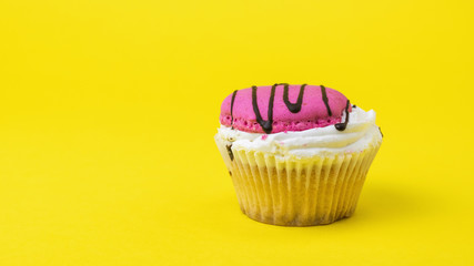 Fresh homemade cupcake decorated with chocolate on a yellow background.
