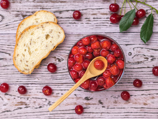 Cherry jam and bread with berries on a wooden table. Homemade jam from the fresh harvest of cherry berries. Flat lay.