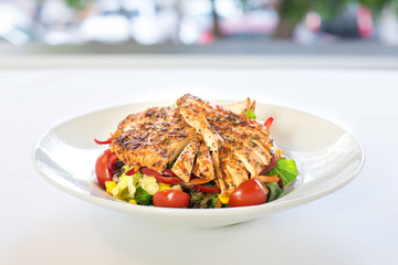 Grilled or roasted chicken salad with green and fresh vegetables. Healthy diet caesar salad meal.