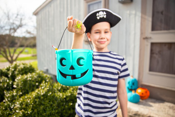 trick-or-treat. the concept of health for children in the Halloween season. boy in a pirate costume holds a teal bucket in Halloween. 
