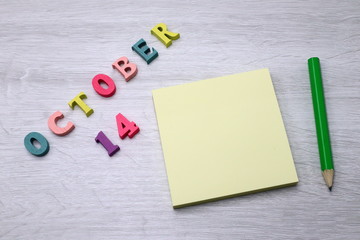 October 14 - Daily colorful Calendar with Block Notes and Pencil on wood table background, empty space for your text or design