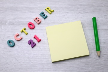 October 21 - Daily colorful Calendar with Block Notes and Pencil on wood table background, empty space for your text or design