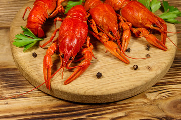 Boiled crayfish on cutting board on wooden table