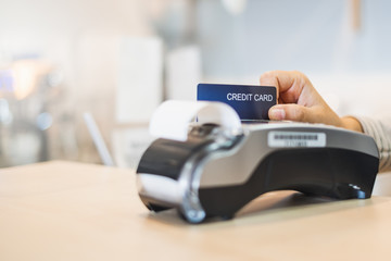 Customer using credit cart for payment to owner at cafe restaurant, cashless technology and credit...