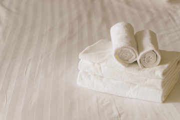 Fototapeta na wymiar white fluffy towels on bed in hotel bedroom. Close up view