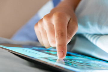 Kinderhand bedient Tablet im Bett vor dem Einschlafen und schläft durch Medienkonsum nicht gut