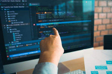 Man hands pointing coding html and programming develop on screen computer.