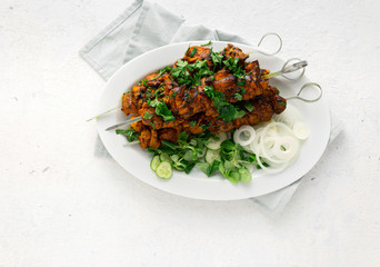 Shish kebab on skewers served on white plate on a white background top view