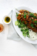 Shish kebab on skewers served on white plate on a white background top view
