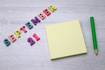 September 21 - Daily colorful Calendar with Block Notes and Pencil on wood table background, empty space for your text or design