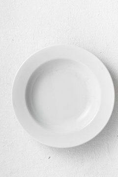 Empty white round plate on a white background top view